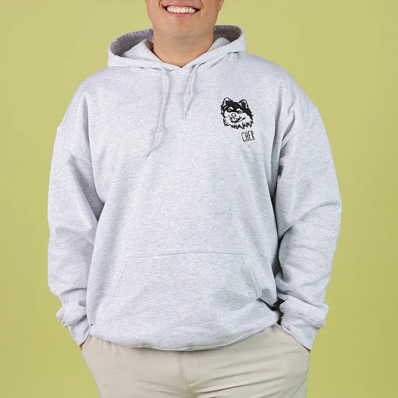 Man wearing a gray hoodie with a small black outline Pomeranian on the left chest