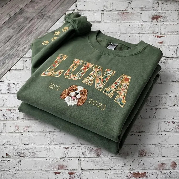 Green sweatshirt with LUNA in floral appliqué letters and a small embroidered spaniel portrait