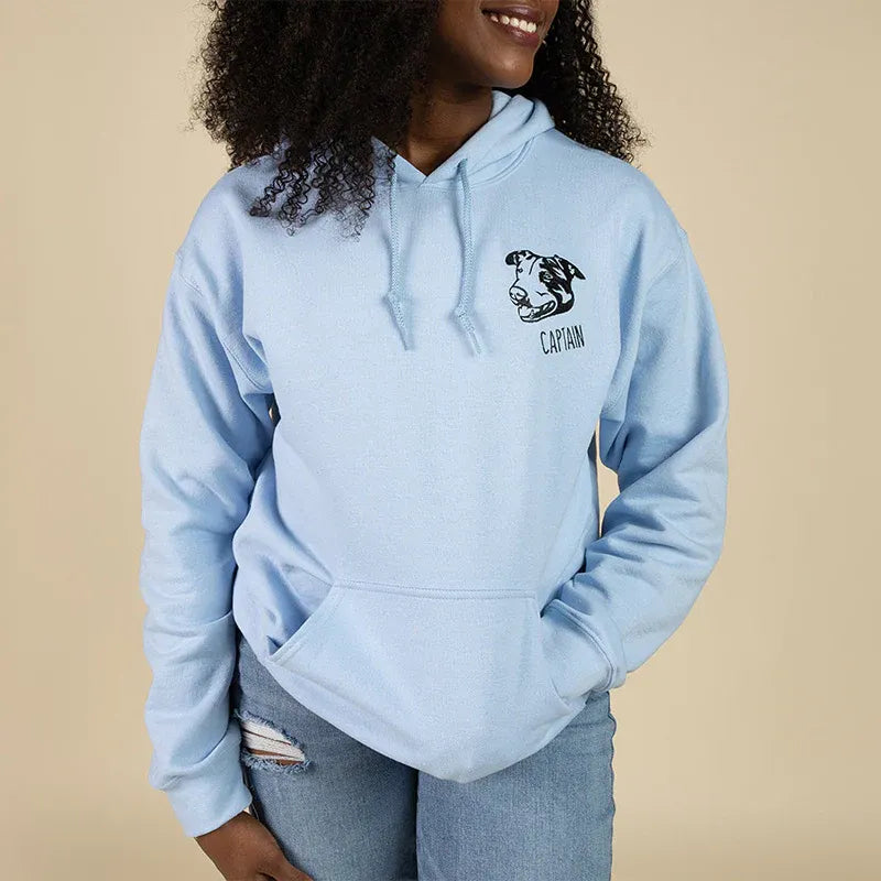 Woman wearing a light blue hoodie with a left chest dog line art and the name Captain