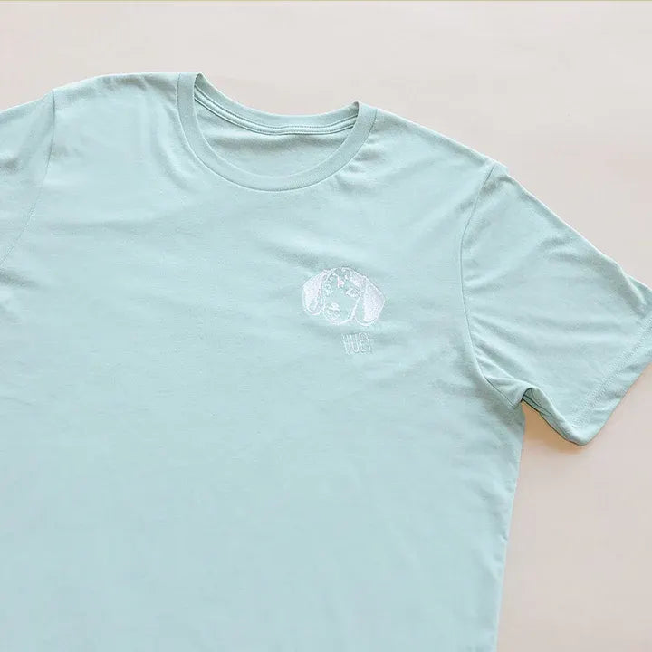 Close-up of a mint T-shirt with a subtle white embroidered pet outline on the left chest