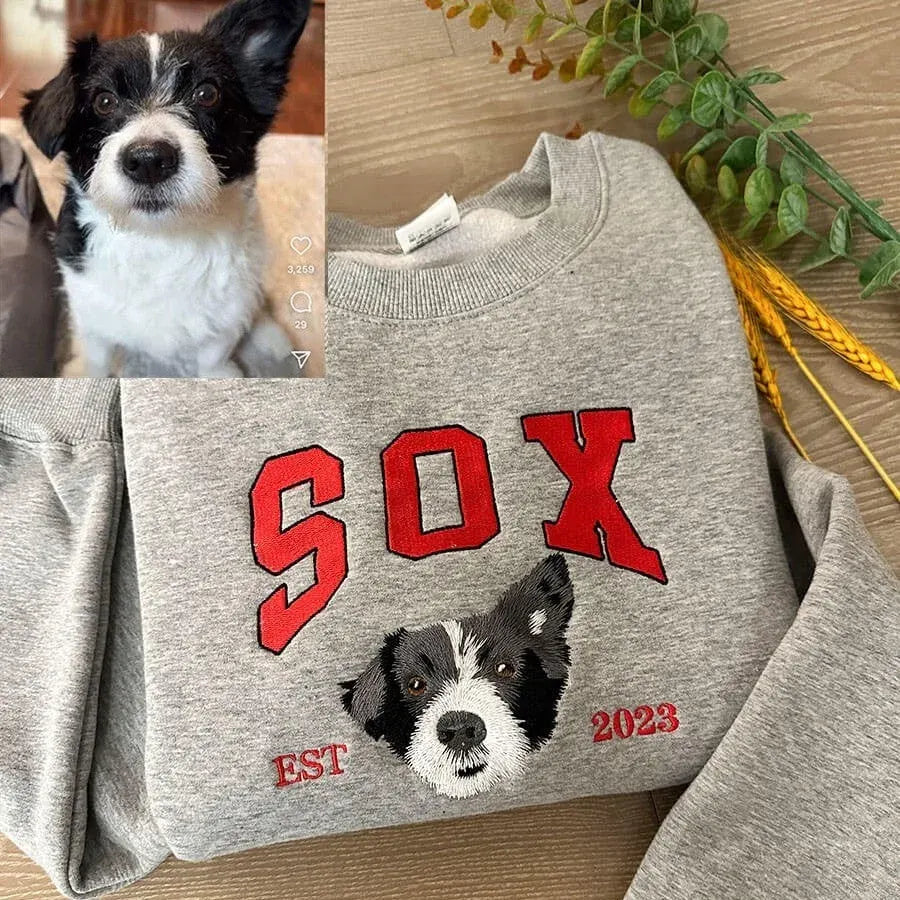 Gray sweatshirt with the name SOX in red collegiate letters above an embroidered black and white dog face and EST 2023