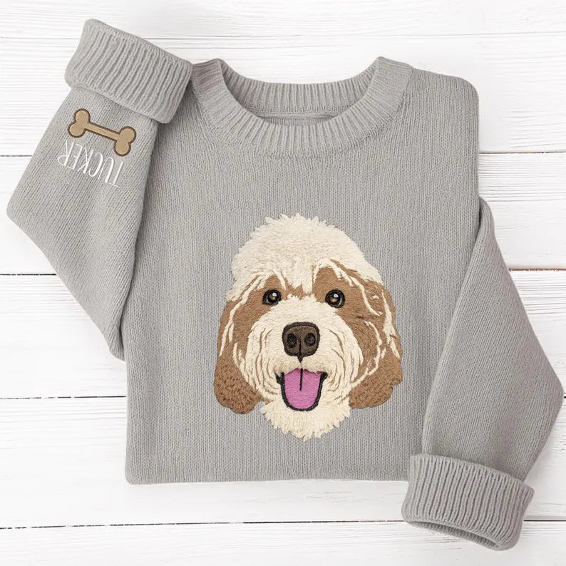 Folded gray knit sweater with dog portrait and personalized sleeve detail