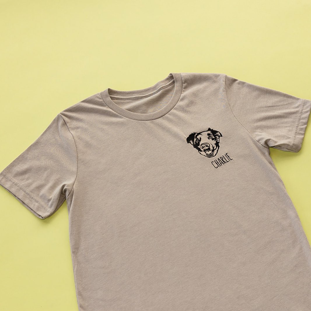 Tan tee with a black line art dog portrait and the name Charlie on the left chest