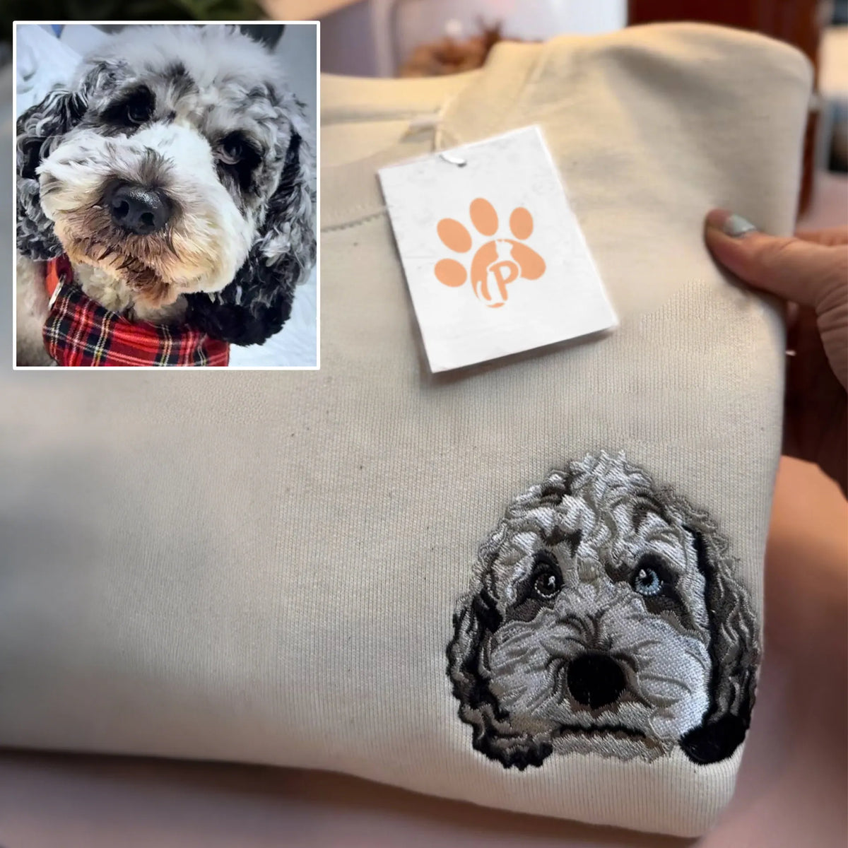 Gray poodle mix face embroidered in detailed black and gray thread on a sand sweatshirt