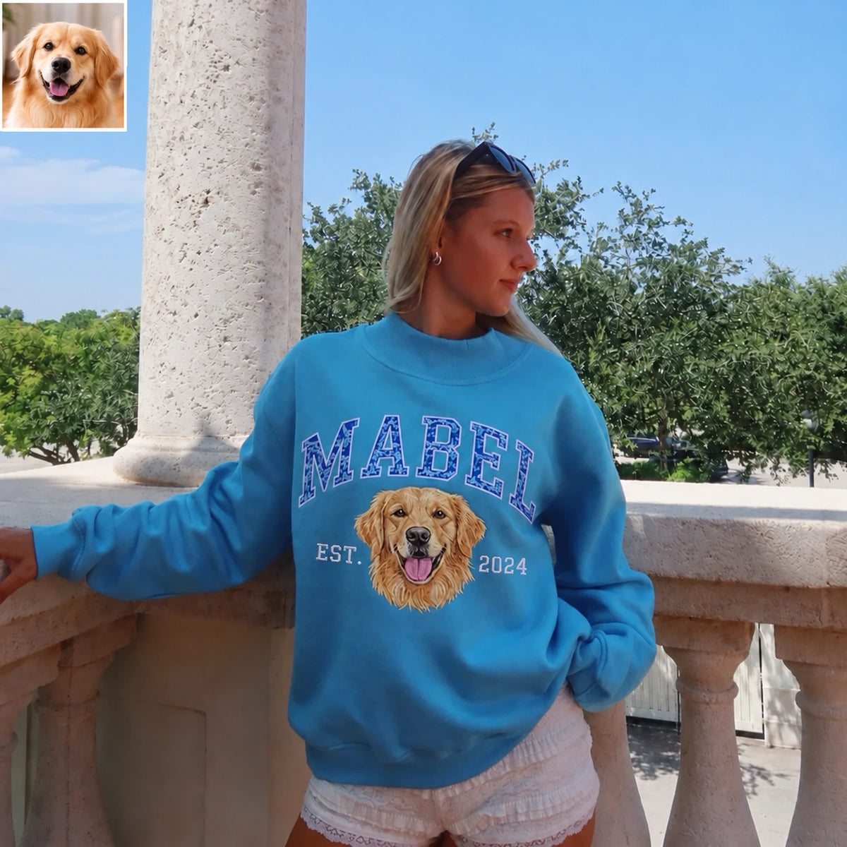 Woman in a bright blue mockneck sweatshirt with MABEL and an embroidered golden retriever, with the original pet photo