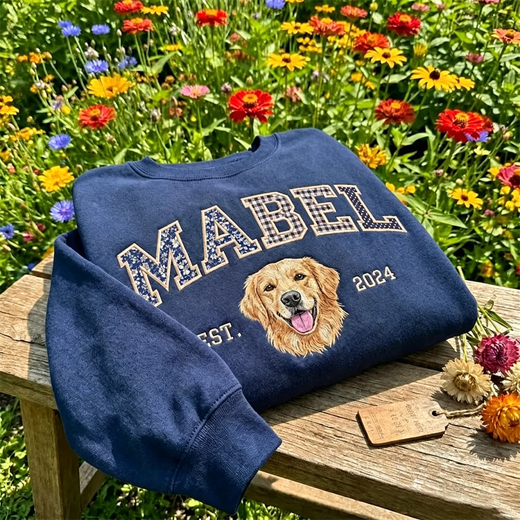 Navy sweatshirt with MABEL in floral patchwork letters and an embroidered golden retriever, in a flower garden