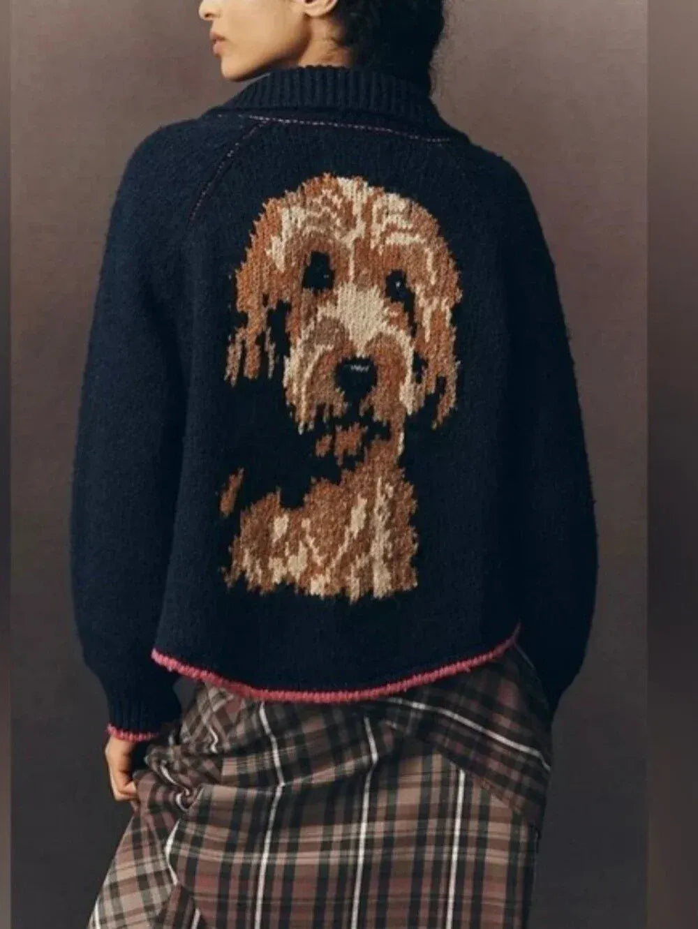 Back of a navy cardigan with a knitted doodle portrait and pink trim