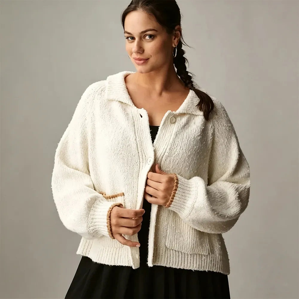 Woman wearing an ivory oversized collared cardigan with patch pockets, front view