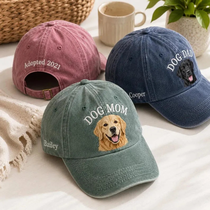 Back of a pink washed cap embroidered Adopted 2021 above the strap, with green DOG MOM and navy DOG DAD caps