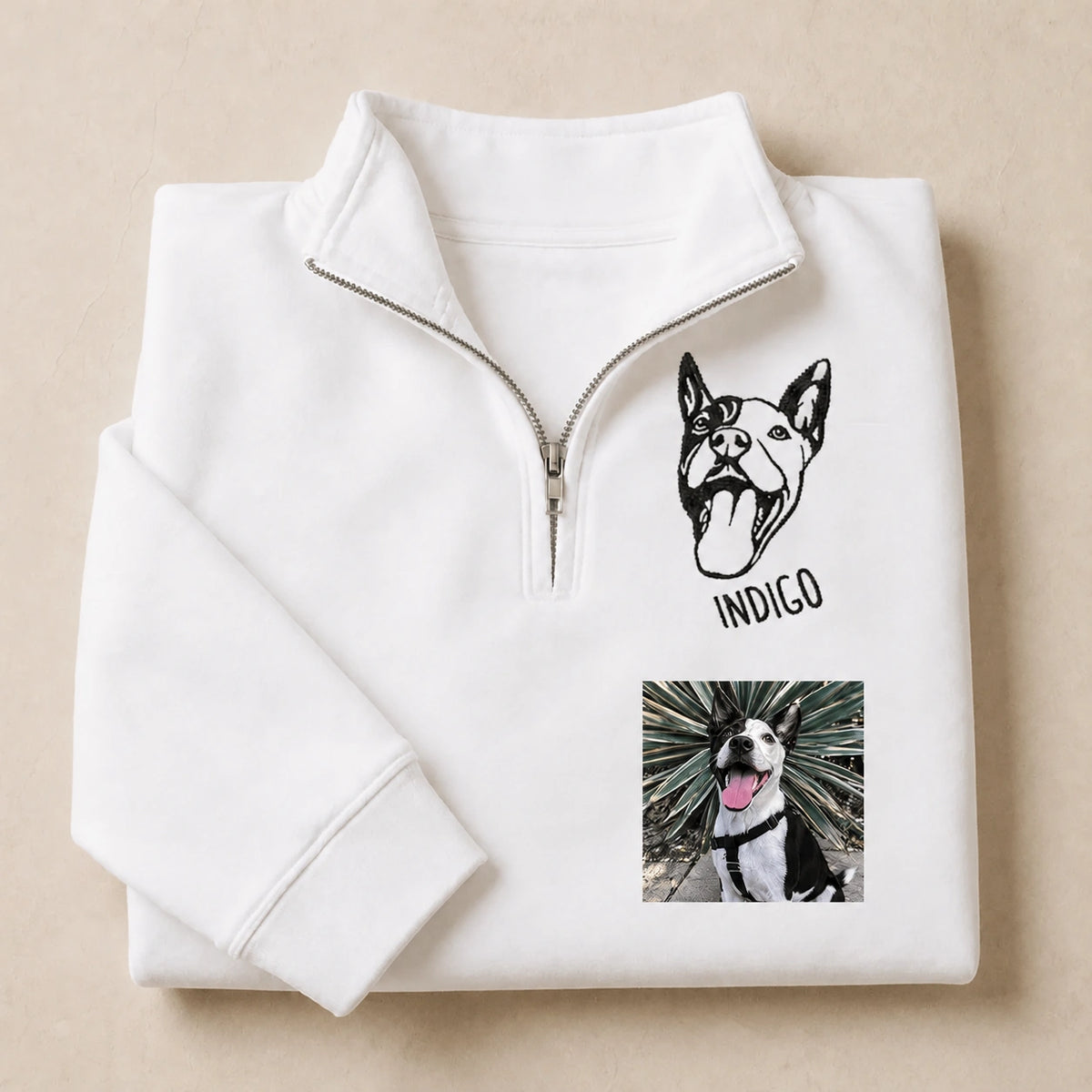 Folded white quarter zip sweatshirt with a line art pit bull named INDIGO and the photo it was drawn from